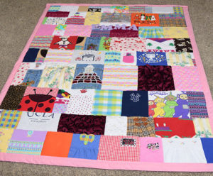 How cute is this- save those baby clothes and turn them into a baby clothes quilt from JellyBeanQuilts.com! So cute! #babyclothesquilt #memoryquilt #onesiequilt #babyclothesblanket